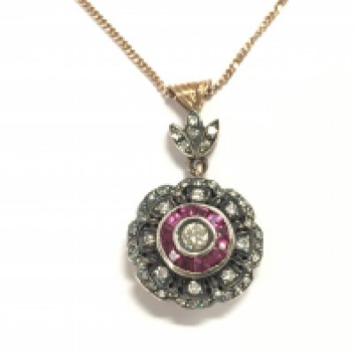 Unhallmarked rose gold and silver topped victorian style pendant set with a central diamond surrounded by rubies and further diamonds. Rubies approx 0.30ct and 0.48ct diamonds. Postage A