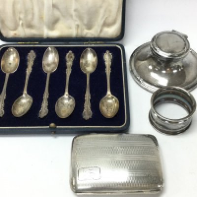 A collection of hallmarked silver items including a cased set of spoons, a cigarette case, napkin ring and an inkwell. Postage Category B