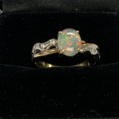 18ct yellow and white gold ring set with a central diamond and flaked with diamond shoulders. Size O. (A)