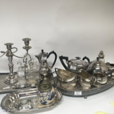 A collection of silver plate trays tea sets a candelabra cases of canteens of cutlery and other items.