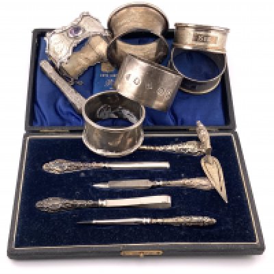 A small collection of hallmarked silver items. To include a manicure set, 6 Hallmarked napkin rings, Needle case, Bookmark. (B)