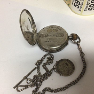 A silver cased button wind pocket watch maker Ariston seen working with attached silver watch chain.