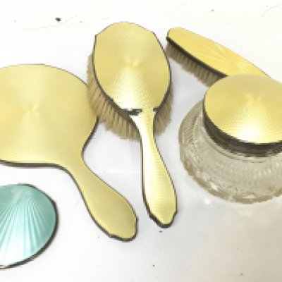 A silver and yellow enamel dressing table set and a blue enamel and silver compact some damage to the enamel. (5)