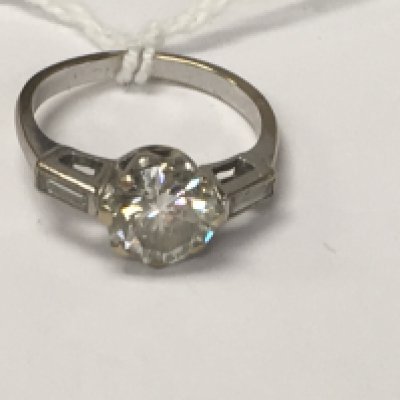 A white gold ring inset with a solitaire diamond 1ct aprox size K .
