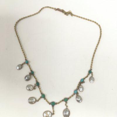 An unusual arts and crafts unmarked yellow metal with stone set charms. Approx weight 11.64 grams.