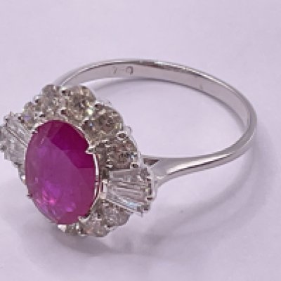 18ct white gold ring set with an oval ruby, surrounded by a halo of RBC and tapered baguette cut diamonds, boxed. Ruby 1.87ct. Diamonds 1.10ct (RBC 0.89ct, tap bag 0.21ct. Ring size approx O. Postage category A.