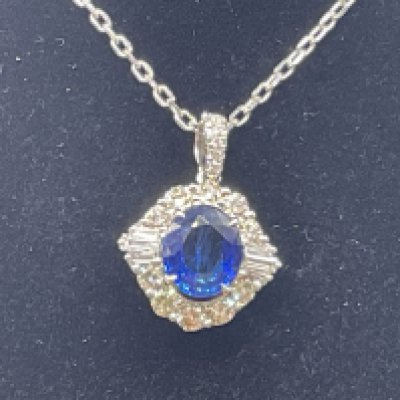 18ct white gold oval sapphire and diamond cluster necklace, on an 18ct white gold chain, boxed. Sapphire 1.42ct. RBC and baguette cut diamonds 0.63ct. Postage category A.