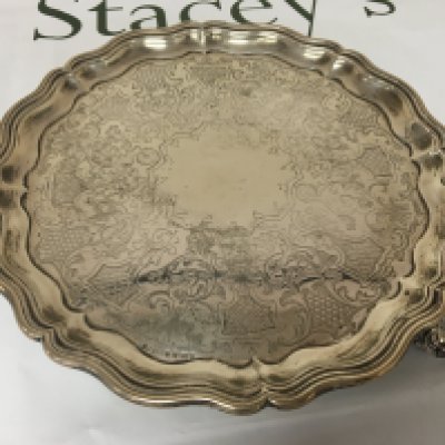 A Victorian silver tray with a shaped edge and scroll feet Sheffield hallmarks.diameter 26cm. Weight 560g