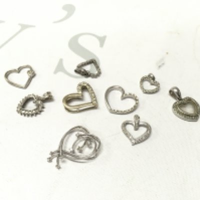 A mixed assortment of mixed carat white gold heart pendants Approx weight 14.7 grams.