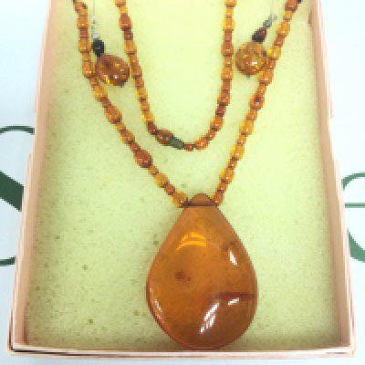 An amber beaded necklace and a pair of matching earrings. Shipping category A.