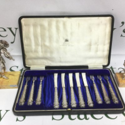 A cased silver handled pickle set and two silver overlaid figures (3). Shipping category B.