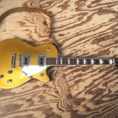A Gretsch G5438 electric guitar in gold sparkle finish. Comes with a soft carry case.