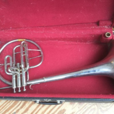 A cased Mellophone with mouthpiece.