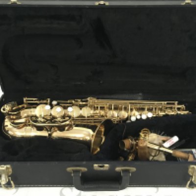 A cased Evette saxophone with accessories.