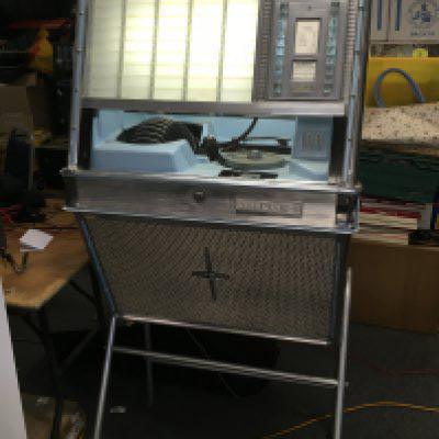 A Rock Ola 430 jukebox in need of restoration. Powers up, turntable spins but does not accept selection.