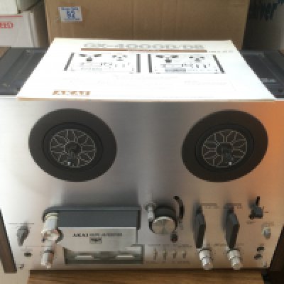 A boxed Akai GX4000D reel to reel player and a box of reels (2). Comes with manual.