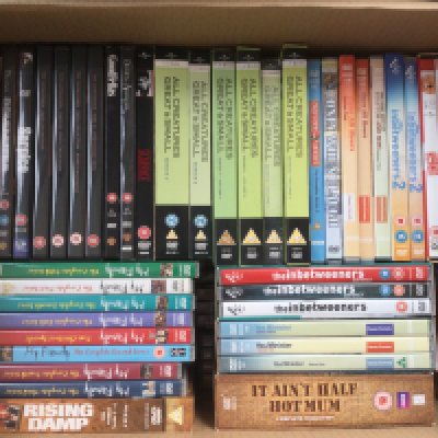 Three boxes of DVDs comprising many TV series and films.