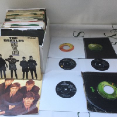A collection of Beatles 7" singles and EPs including a US pressing of I Feel Fine b/w She's A Woman.