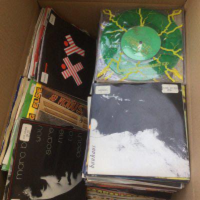 A box of 7" singles by various artists including Kate Bush, The Jam, Bauhaus, PiL and many more.