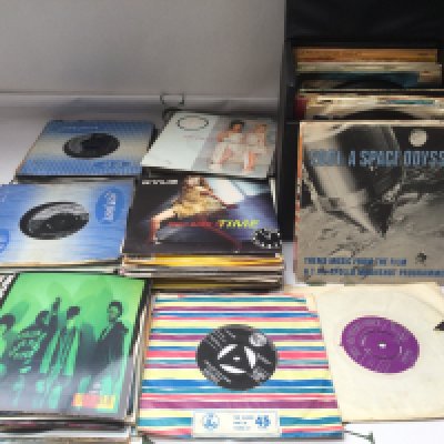 A record case and a bag of 7" singles and EPs by various artists from the 1950s onwards.