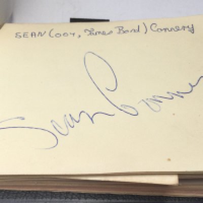 An autograph booklet containing various signatures including Sean Connery, Georgie Fame, Stirling Moss and others.