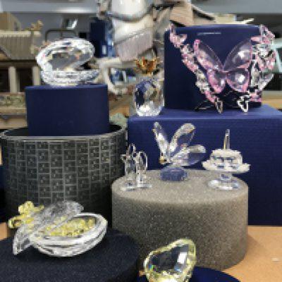 A collection of various Swarovski items including oyster and Pearl, pineapple, heart shaped trinket box with miniature yellow hearts, butterflies, ballet shoes, birthday cake, etc