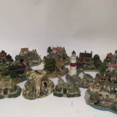 A collection of Lifeboat RNLI resin lifeboat station and buildings three dimensional resin sculptures other conforming Cottages and a Royal Doulton ceramic tree stump money box.