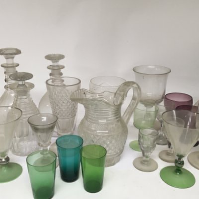 A collection of early and later 19th century glass including George III ring neck decanters a glass wine funnel coloured drinking glasses and other glass.