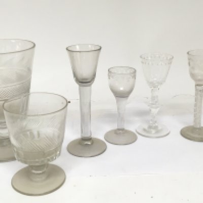 Four 18th century drinking glasses with air twist and cut stems and wheel etched decoration and two 19th century cut glass rummers and a glass candle stick hight