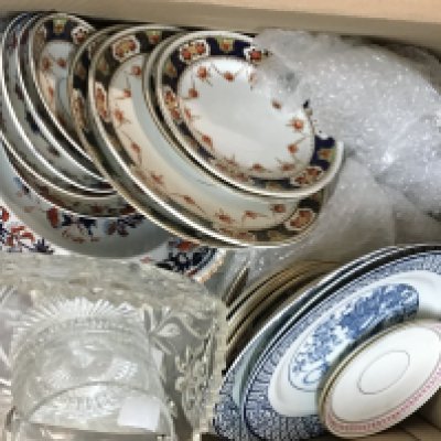 A box containing a collection of decorative ceramics and glass.