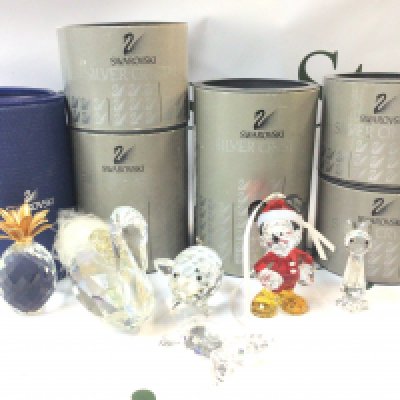 A collection of boxed Swarovski Crystal figures including a cat, Santa Mickey Mouse Christmas ornament, pig, swan, baby sea turtle and a pineapple. Postage category B