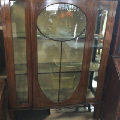 A Edwardian mahogany display cabinet the glazed door enclosing fitted shelves on cabriole Legs .