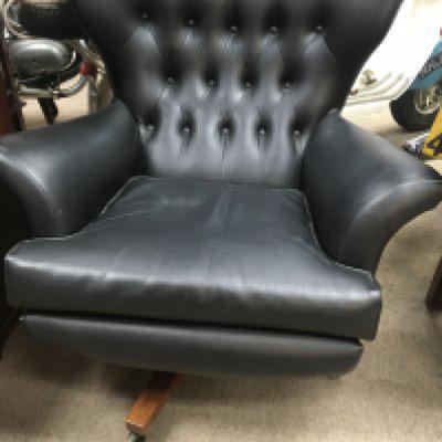 A 1970s open back swing arm chair with button back .