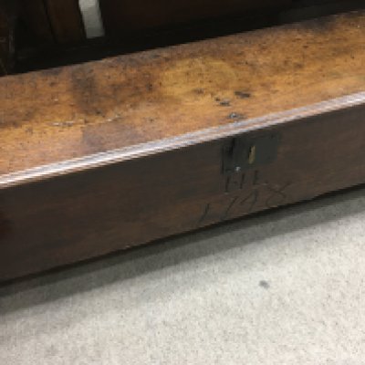 A oak coffer , shepherd&rsquo;s chest the regular lid above a carved front Dated 1748 .