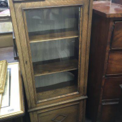 An oak display cabinet fitted with a single glazed door with cupboard under. Hight 135cm width 54cm.