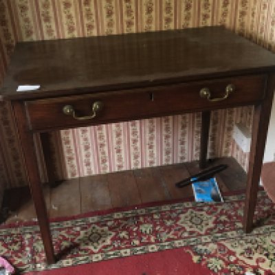 A George III table the rectangular top above a single drawer on square legs.