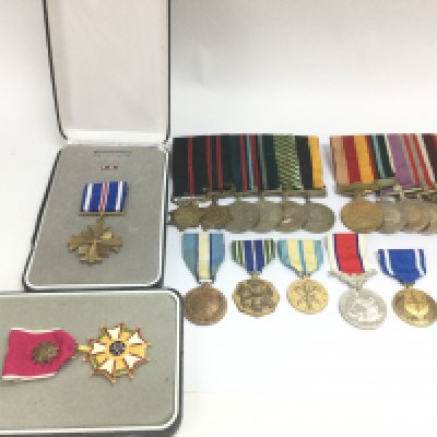 A collection of various war medals including British Hors De Combat line of duty medal, US armed forces reserve medal, US army achievement medal, Pakistan Campaign medals, US distinguished flying cross, Legion of Merit officer. Postage category B