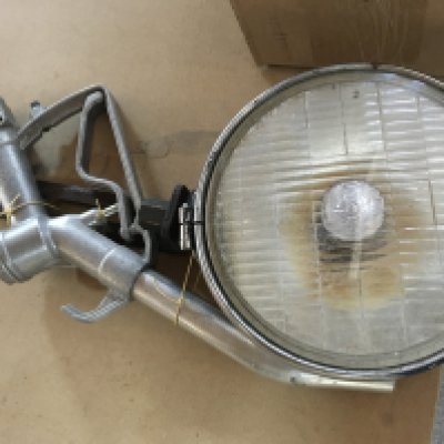 A vintage petrol pump nozzle and car spotlight