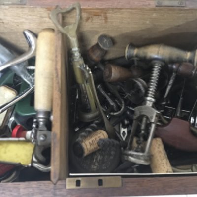 An oak box containing a quantity of Vintage and later cork screws.