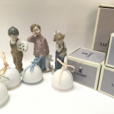 A Collection of boxed porcelain Lladro Christmas tree bell decorations and three porcelain Nao figures. This lot cannot be posted