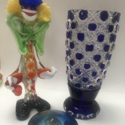 Glassware comprising paperweight clown and blue cut glass vase .