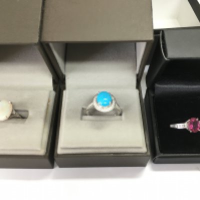 A collection of three 9ct white gold rings set with various stones including opal. 10.48g total weight.