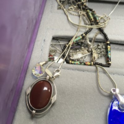 A folder containing various silver and costume necklaces.