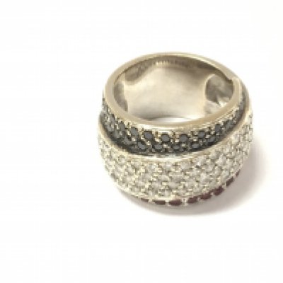 An unmarked white gold ring set with black and white diamonds and red stones. Size M and 17.2g.