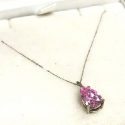 A 9ct white gold chain with a pink stone pendant , 1.8g total weight. Postage category A