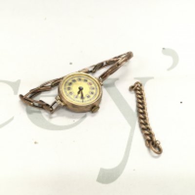 A gold cased watch and a loose piece of gold chain.