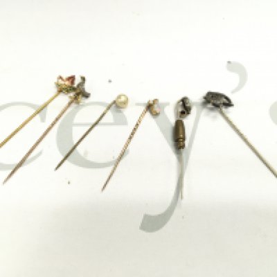 A small collection of pins including some gold examples.