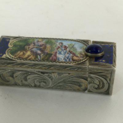 A Quality Continental silver (800) lipstick holder decorated with an enamel oval with figures and engraved silver parcel gilt interior with a spring loaded mirror. Length 6cm