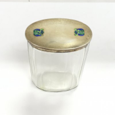 A Liberty and co Archibald knox silver lidded glass dressing table jar with celtic enamel circa 1915. Good condition but very small amount of enamel missing.
