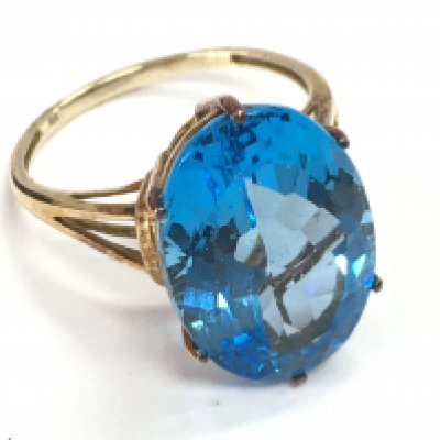 A 9 carat gold ring set with a large blue gemstone , 5.3g total weight. Size S. Postage category A